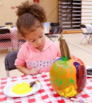 Little girl paints pumkin at RICFest